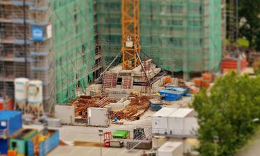 A construction site with a crane base and piles of materials.